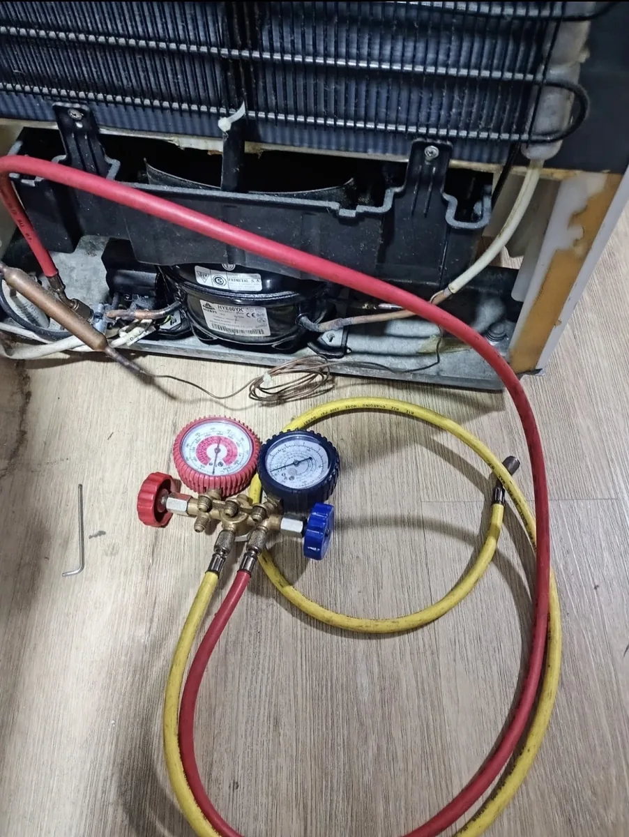 Manómetros conectados al sistema de frío de una heladera durante una carga de gas